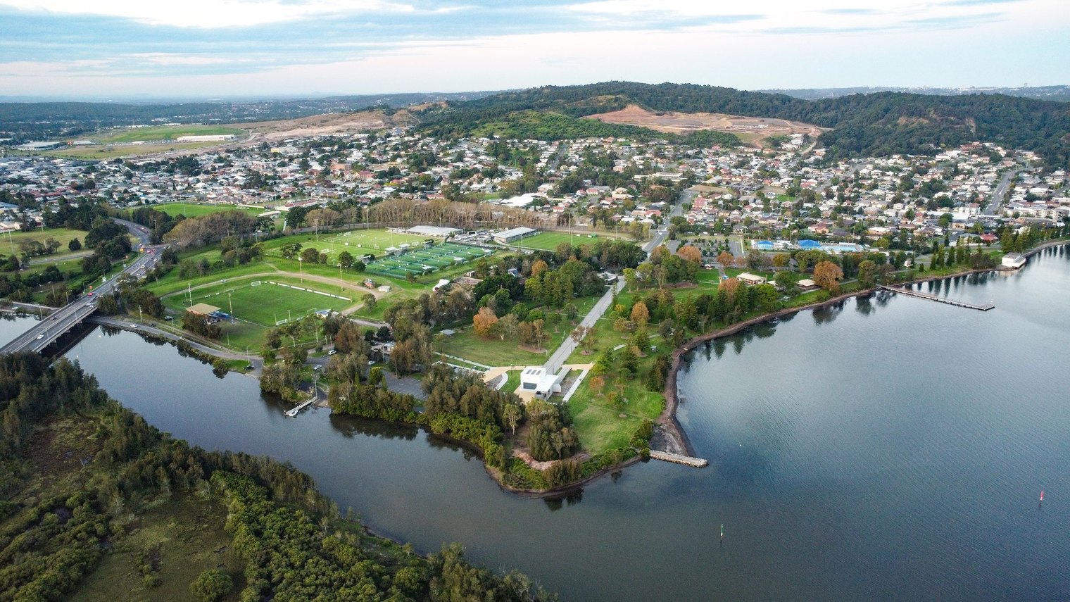 Aerial view over Speers Point on Lake Macquarie in New South Wales, housing, sports fields and parkland along the lake edge.