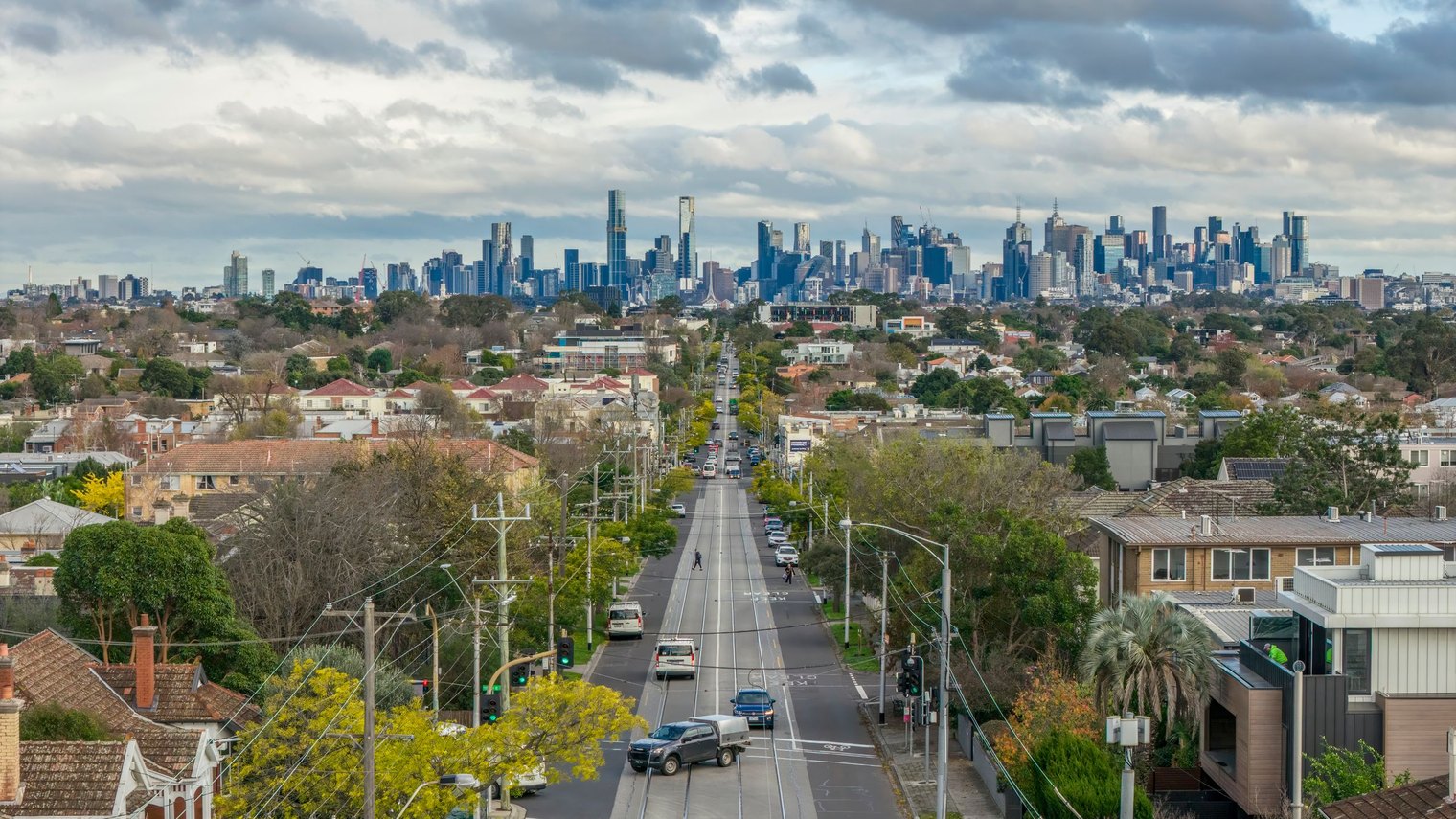 A Melbourne tram route running through an established residential suburb with the city skyline on the horizon.